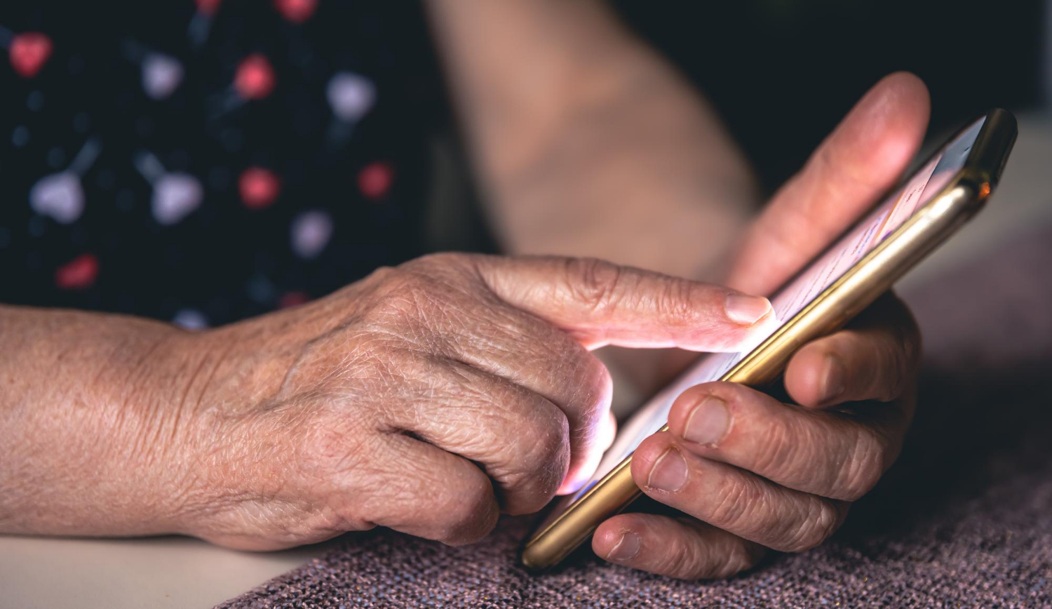 Közeli kép egy idős nőről, amint telefont tart | Forrás: Freepik
