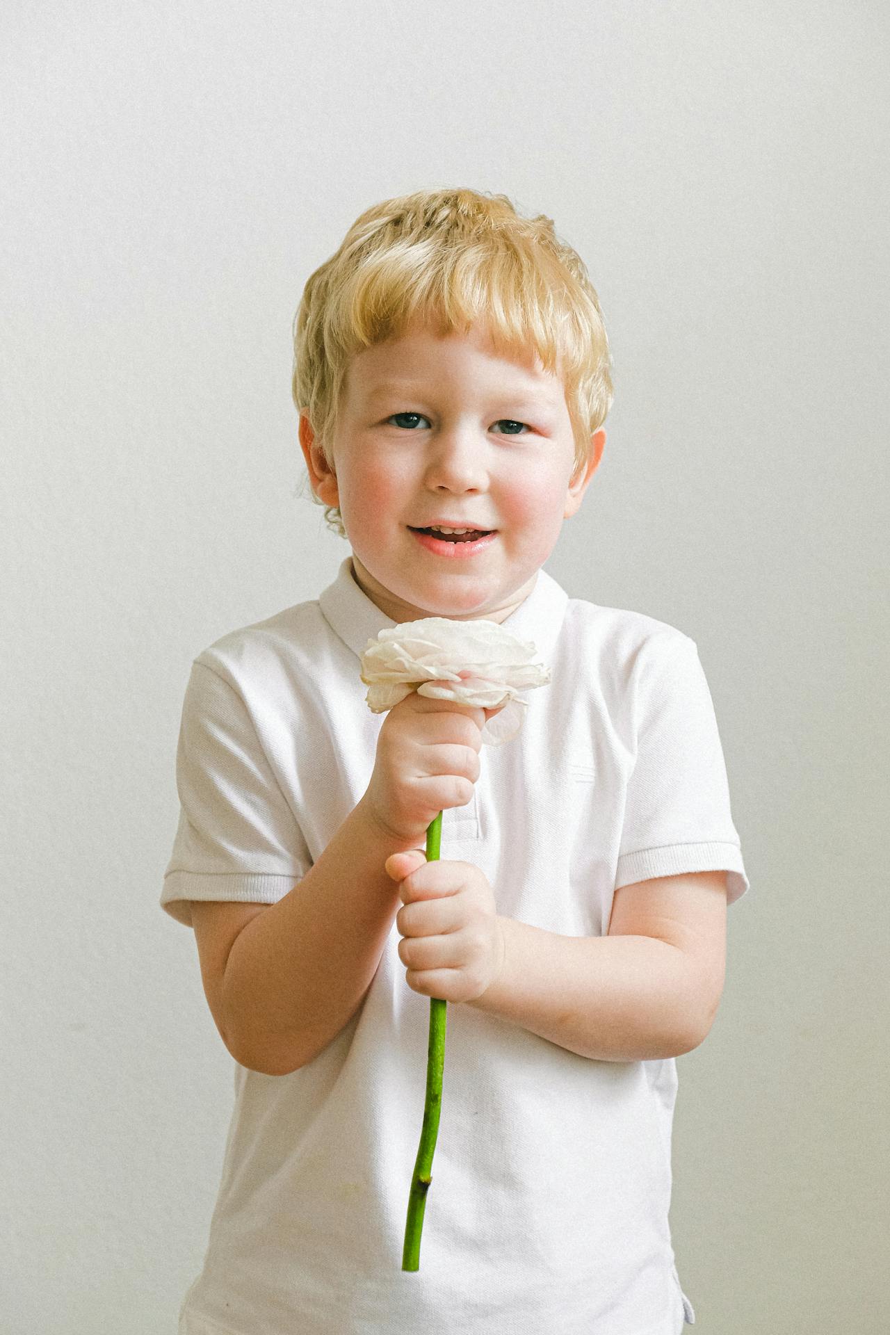 Izgatott kisfiú virággal a kezében